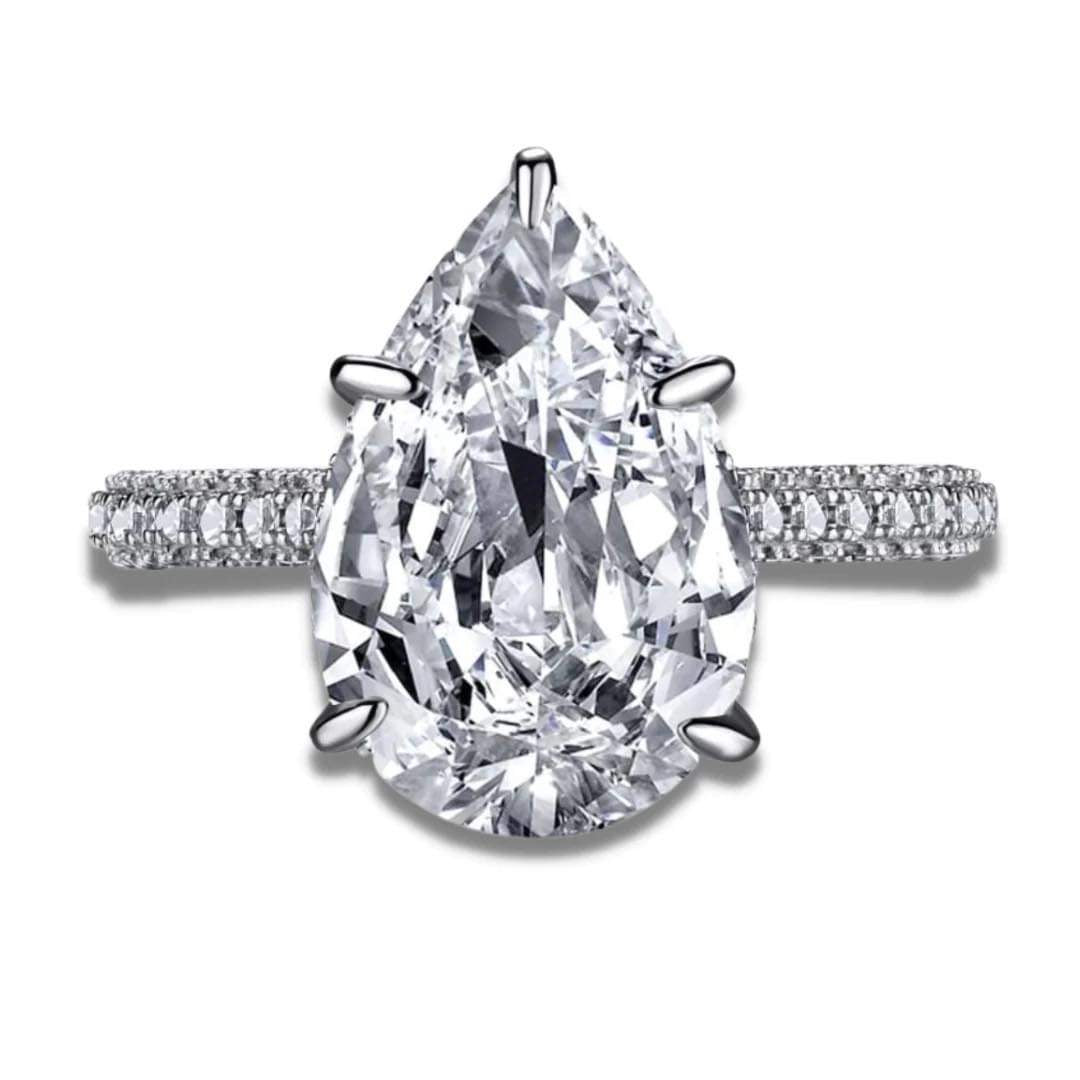 A silver ring with a large pear-shaped clear stone set in the center, with smaller stones around the band.