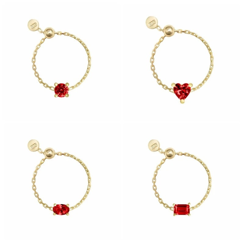 Four gold chain rings with different gemstone designs on a white background
