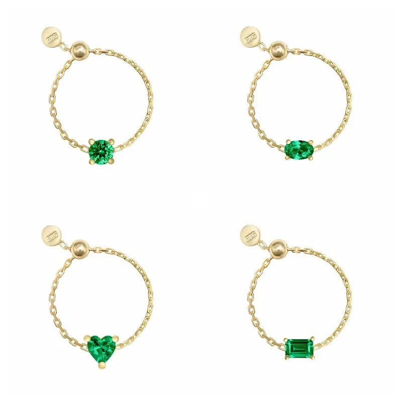Four gold chain rings with different gemstone designs on a white background