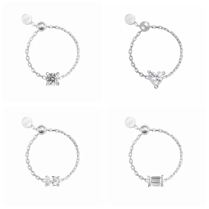 Four silver chain rings with different gemstone designs on a white background