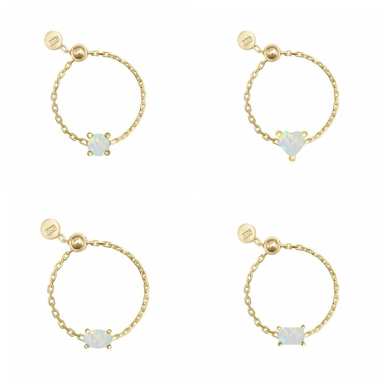 Four gold chain rings with different gemstone designs on a white background