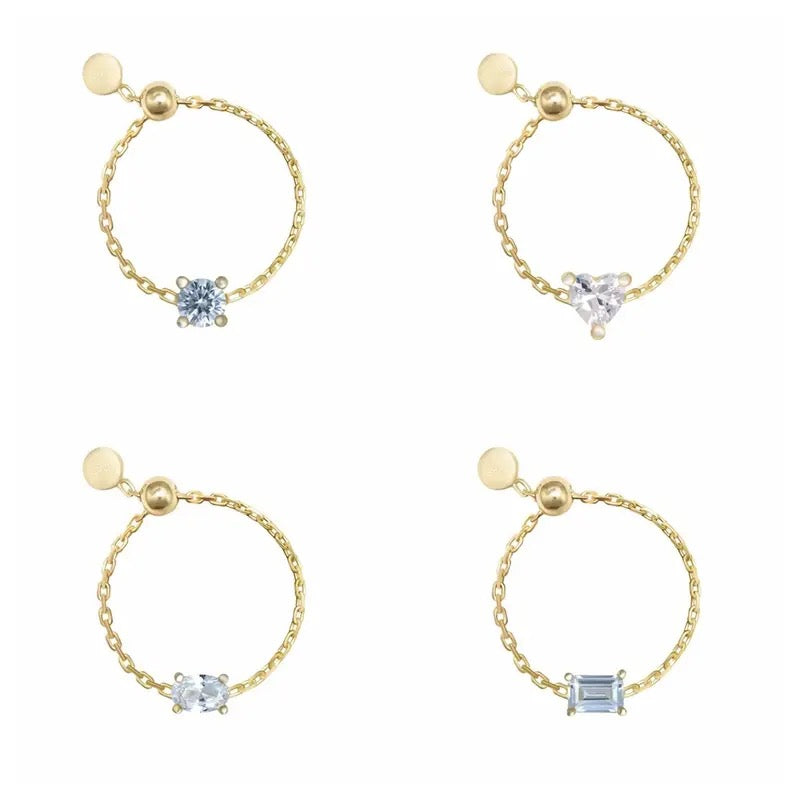 Four gold chain rings with different gemstone designs on a white background