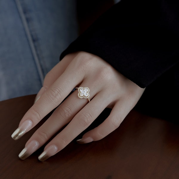 A silver clover-shaped ring with multiple clear gemstones and a rhodium plating.