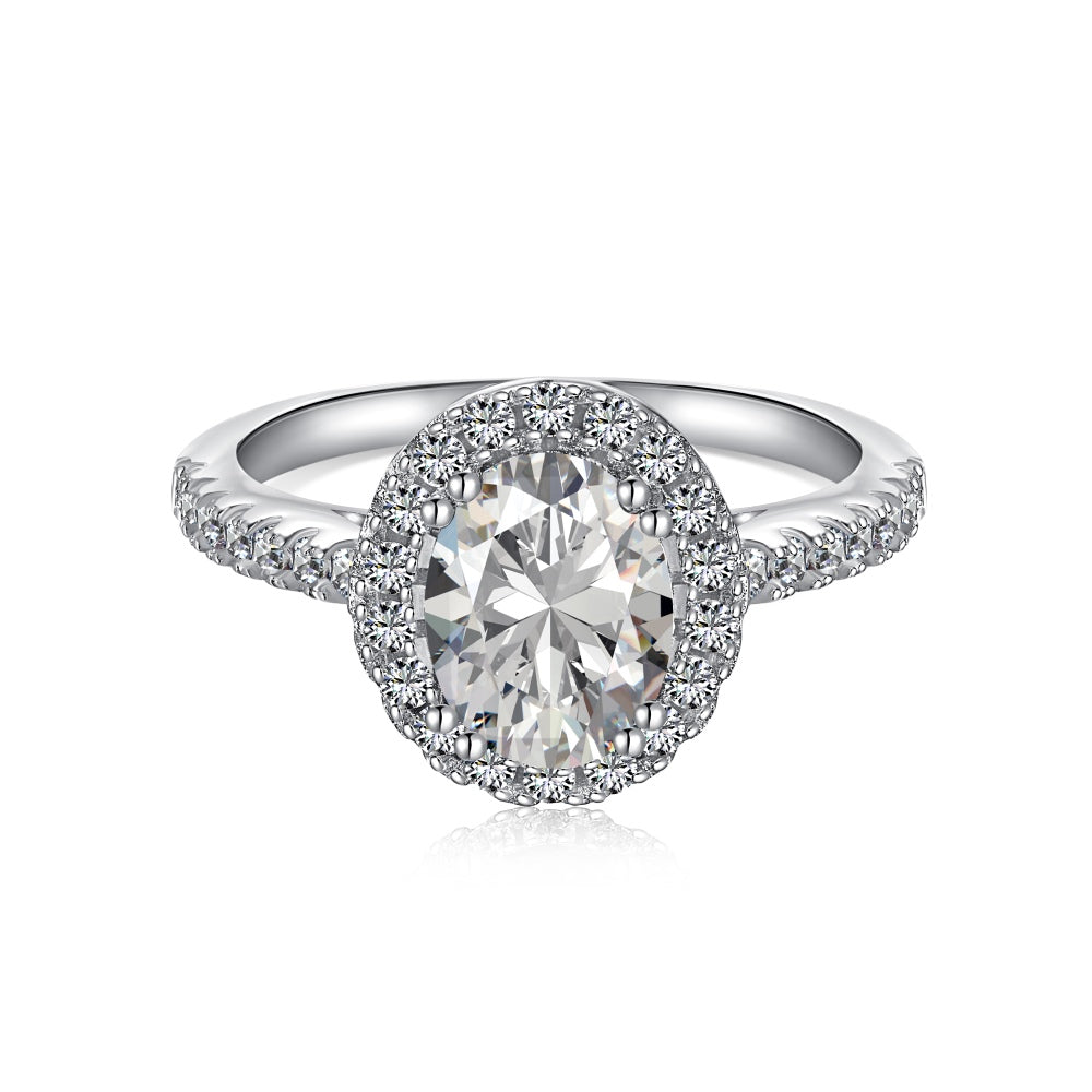 An oval halo ring with a main stone size of 6mm by 8mm, set in a white silver band, surrounded by smaller stones.