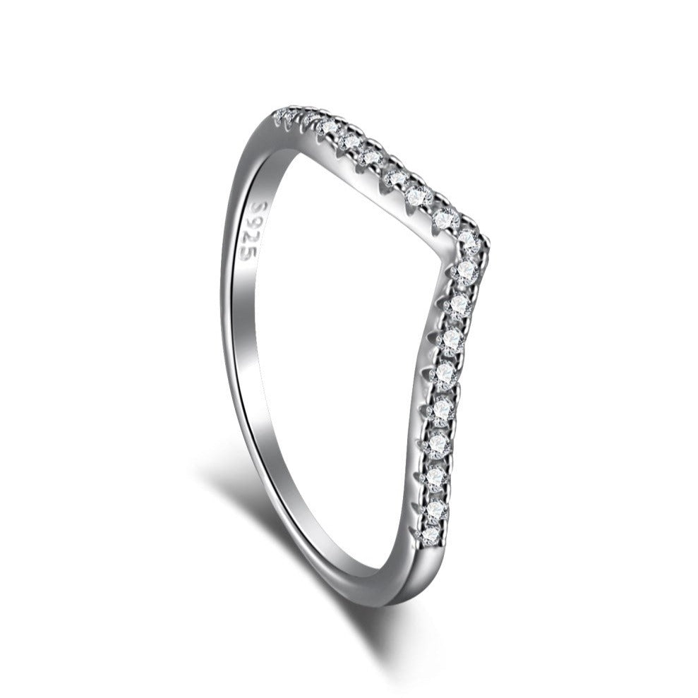 A silver ring featuring a single zircon stone with a wishbone design on the band.