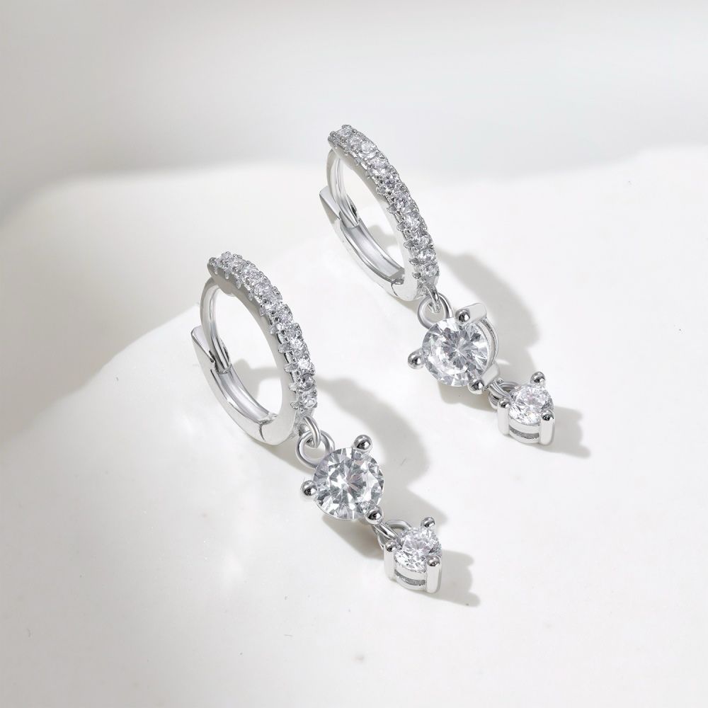 A pair of silver gold-plated hoop earrings with drop-shaped settings containing cubic zirconia stones.