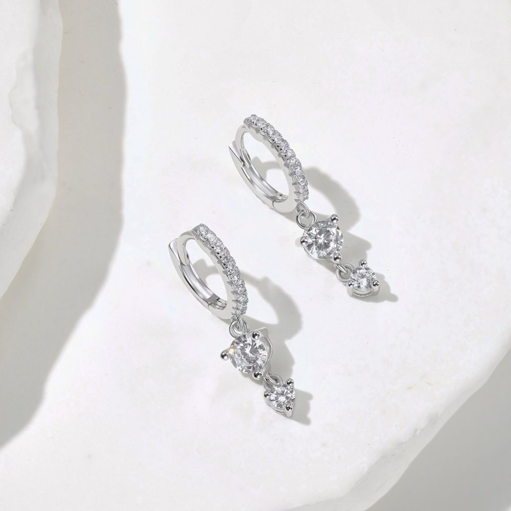 A pair of gold-plated silver hoop earrings with drop-shaped settings containing cubic zirconia stones.