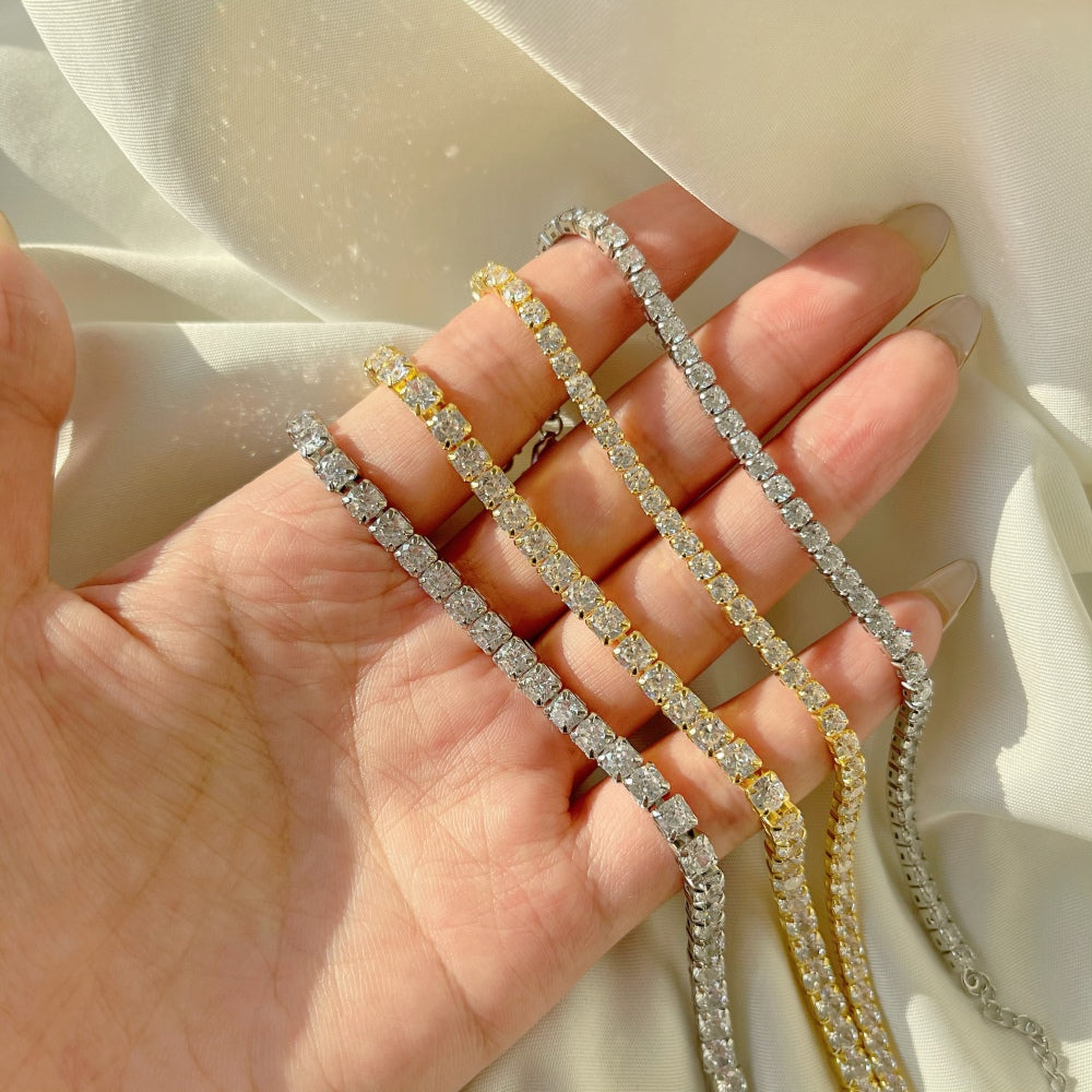 4 sterling silver tennis bracelets with gold/silver accents and cubic zirconia stones.