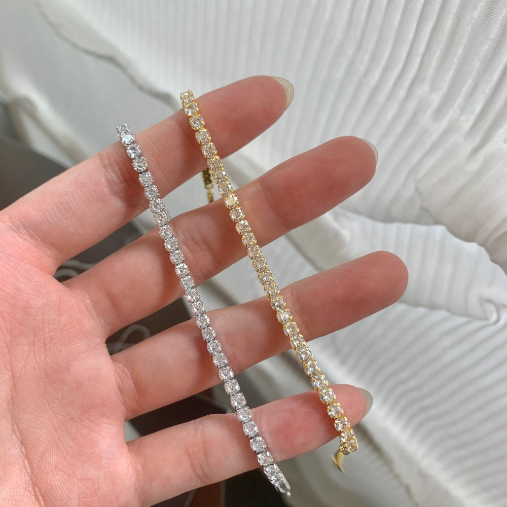 925 Sterling silver tennis bracelet with gold/silver accents and cubic zirconia stones, featuring a clasp closure.