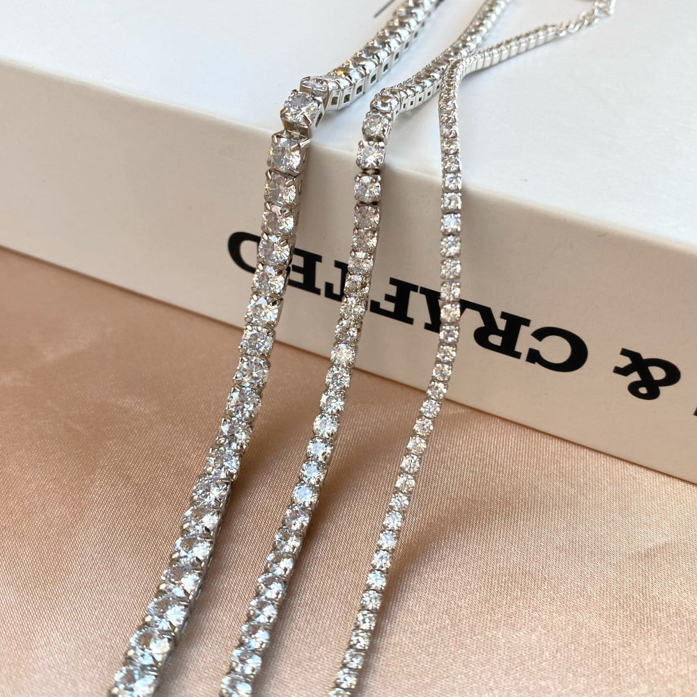 Three sterling silver tennis bracelets with silver accents and cubic zirconia stones, featuring a clasp closure.