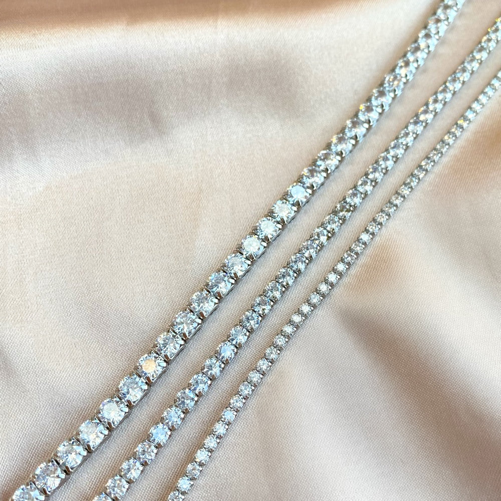 3 sterling silver tennis bracelets with silver accents and cubic zirconia stones.