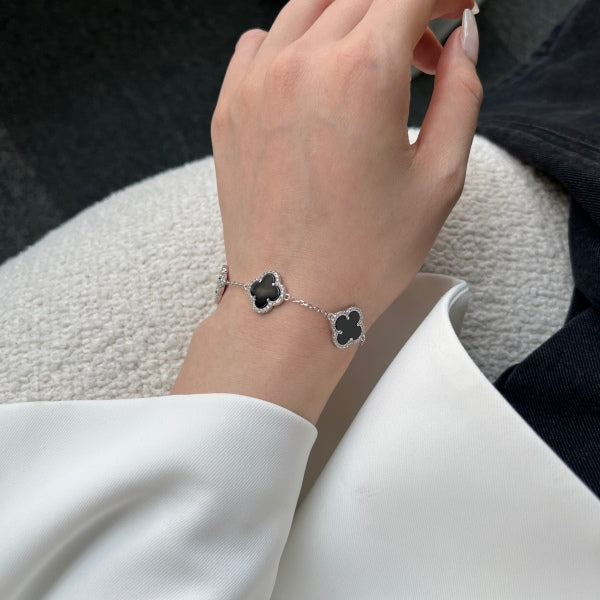 Elegant 925 sterling silver bracelet featuring clover design with black shell accents with an adjustable chain.