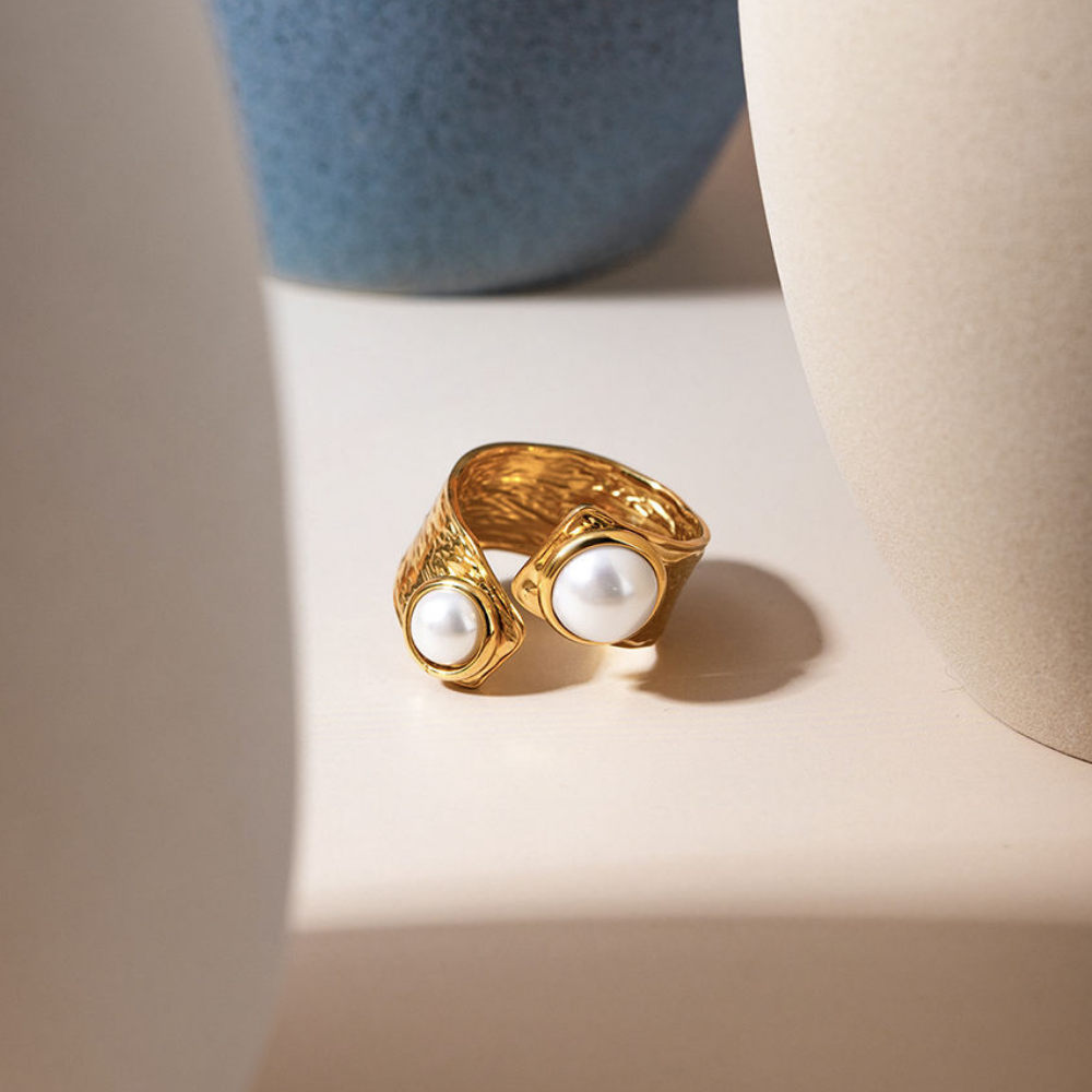 Gold ring with pearls on a light surface