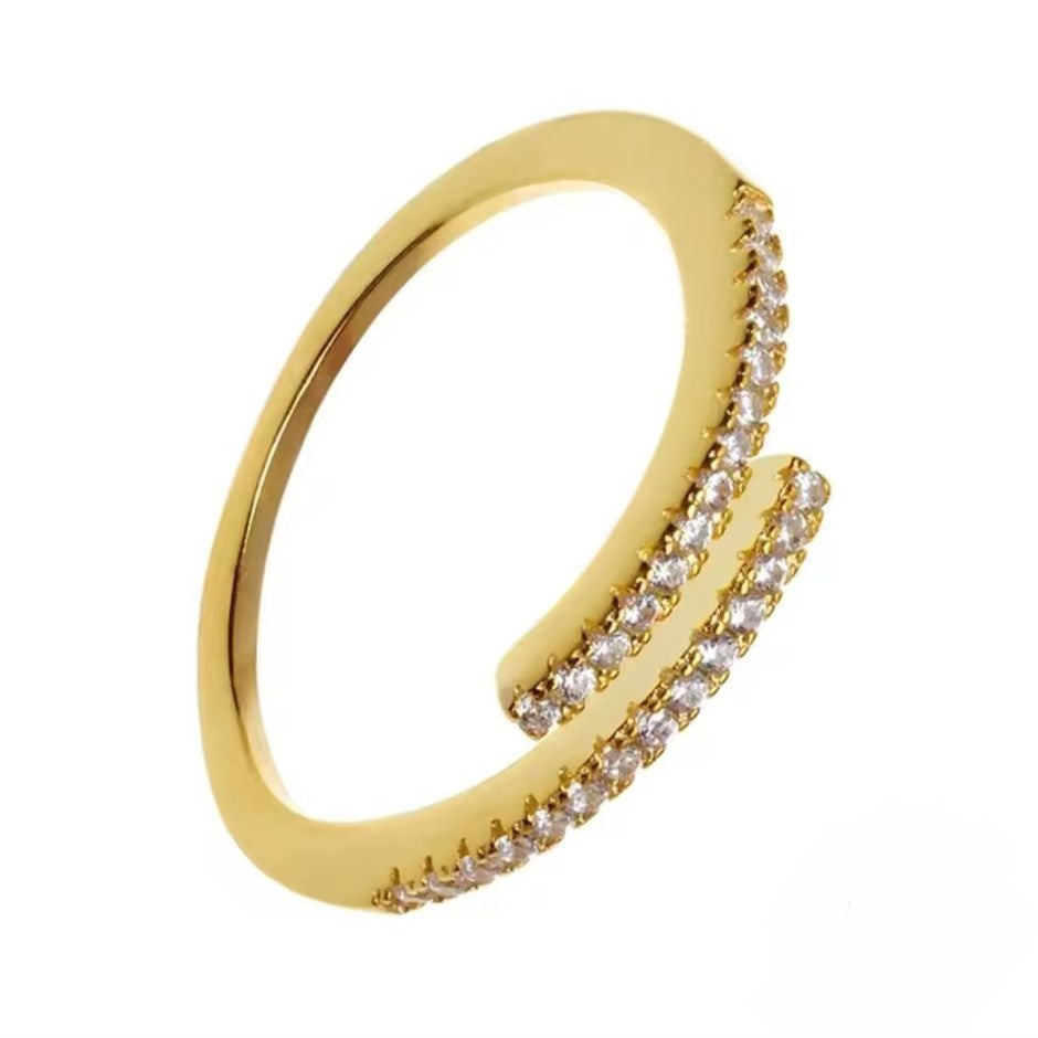Adjustable gold ring with clear small gemstones on a white background
