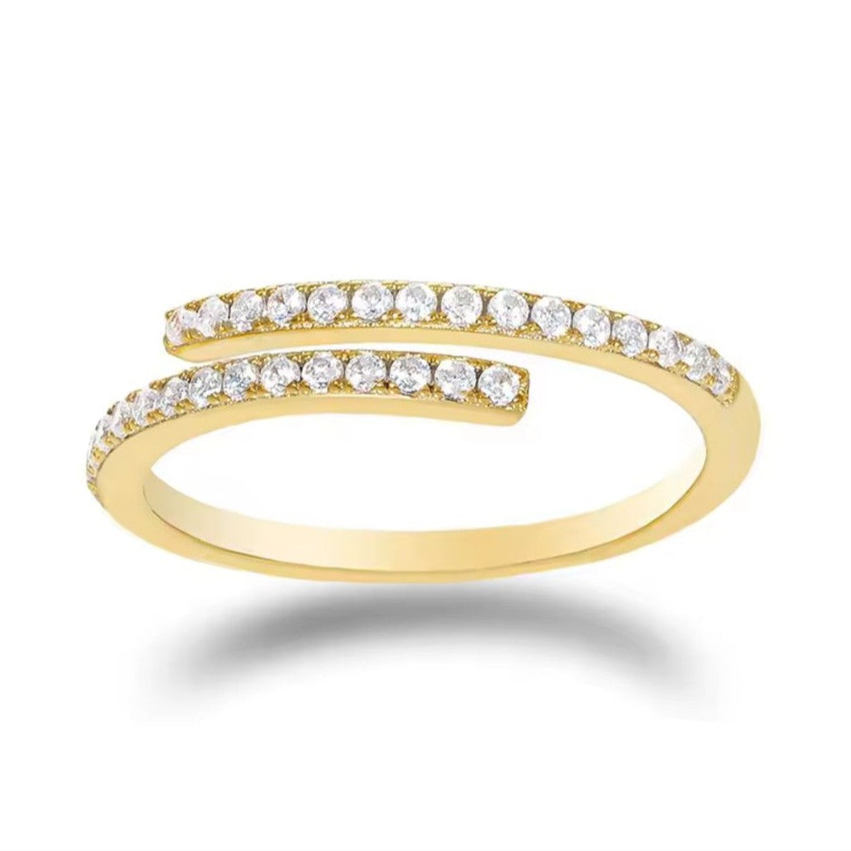 Adjustable gold ring with clear small gemstones on a white background