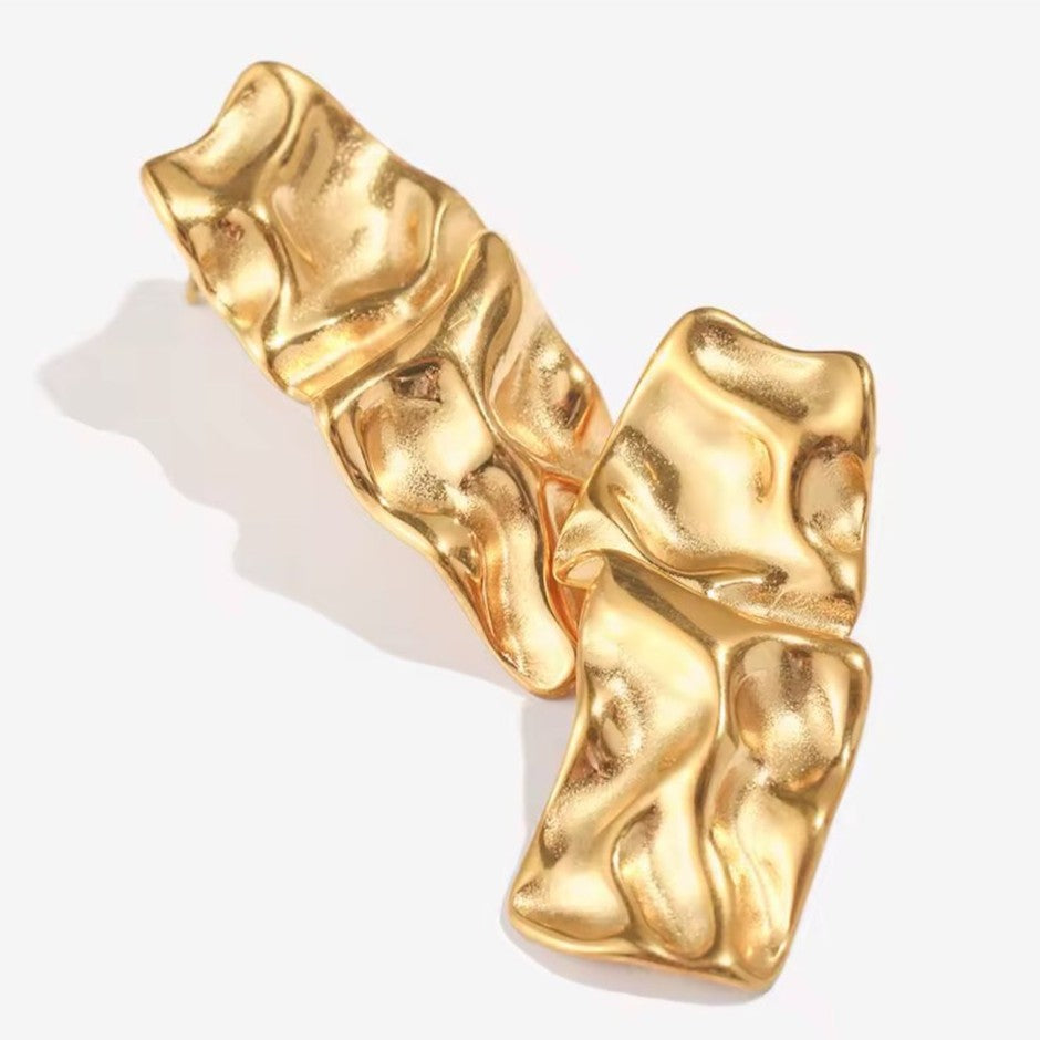 Gold textured earring on a white background