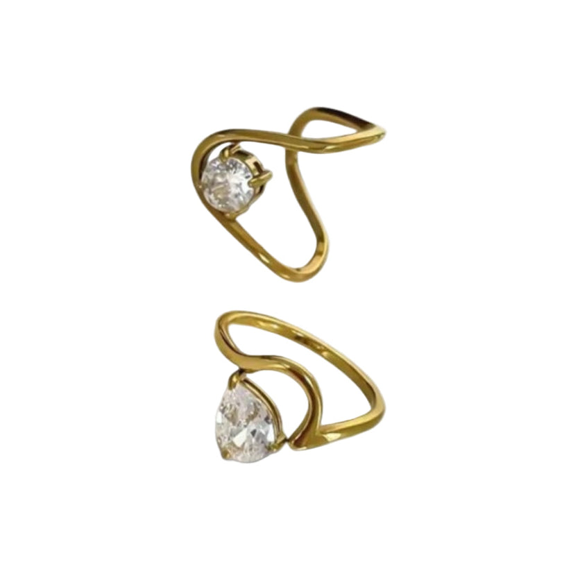 Pair of circular teardrop gold rings with clear gemstones on a white background