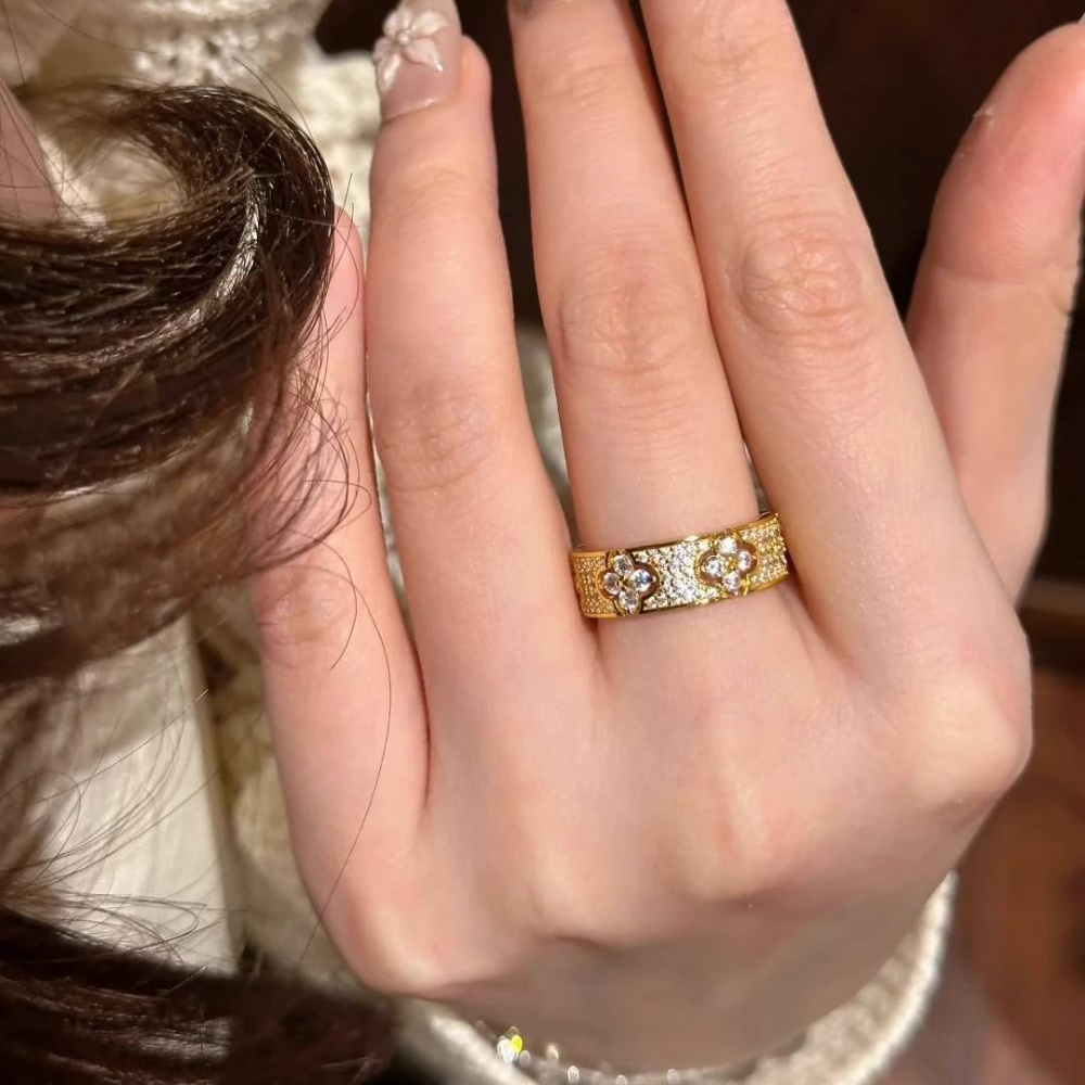 Close-up of a hand wearing a gold ring with diamonds.