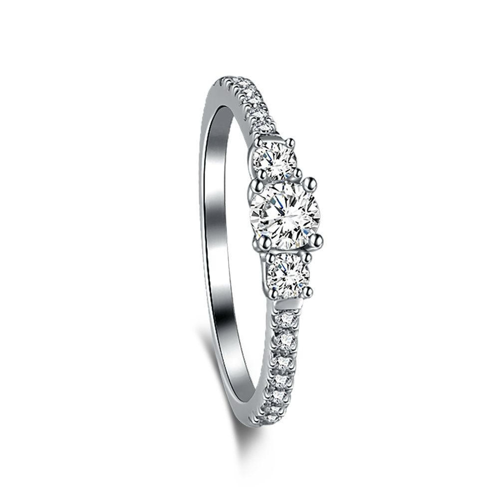 A dainty engagement ring featuring a central cubic zirconia stone with smaller stones on the band, set in a silver-tone mounting.
