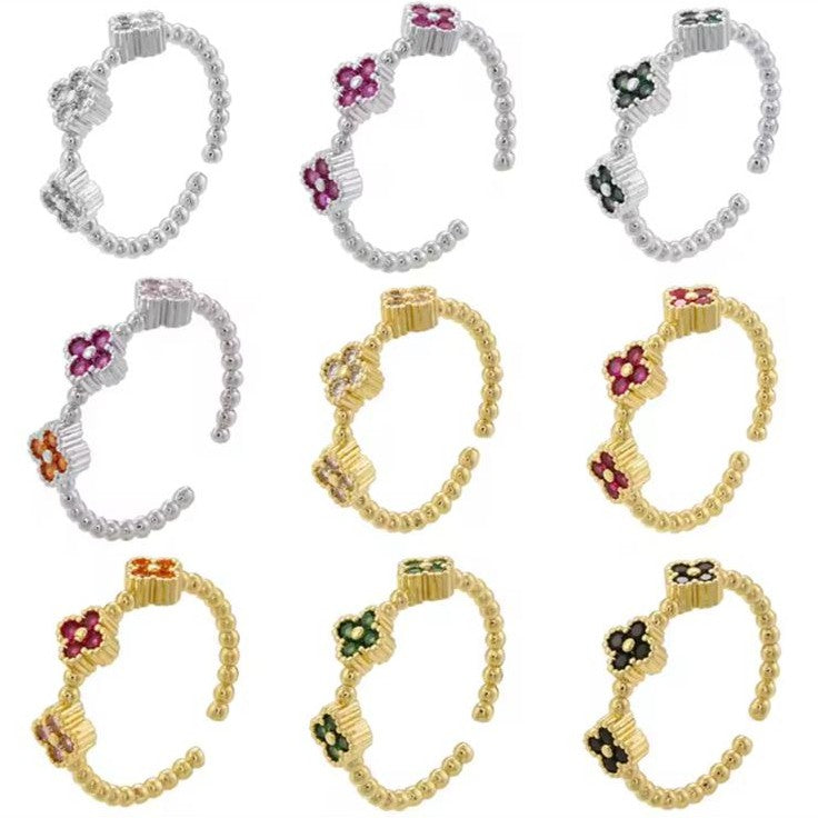 Set of gold and silver adjustable rings with floral designs on a white background