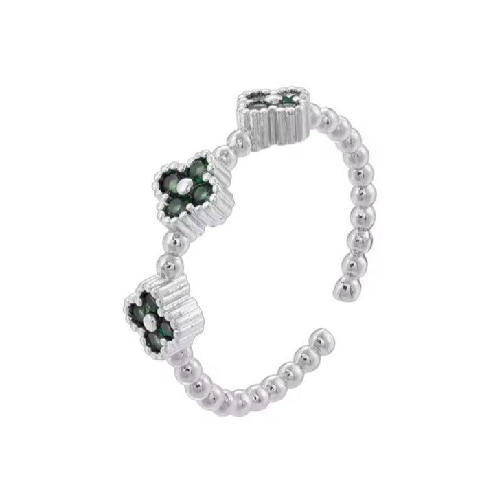 Adjustable ring with clover designs, crafted from silver metal, displayed against a white background