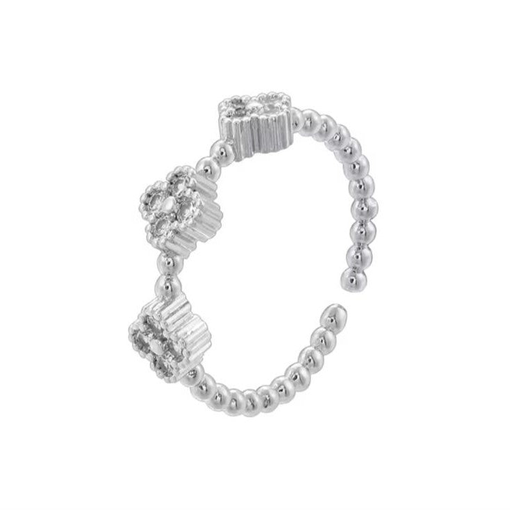 Adjustable beaded ring with clover designs, crafted from silver metal, displayed against a white background