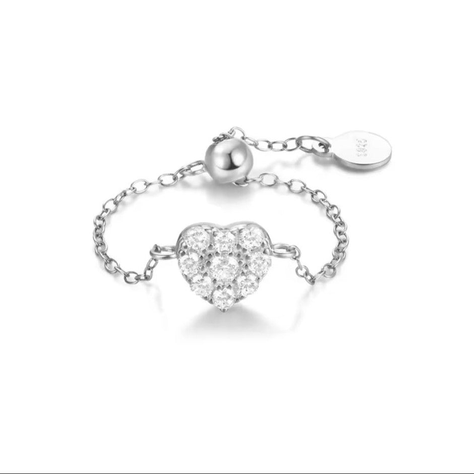 A silver-colored adjustable chain ring with a sparkling diamanté heart centerpiece.