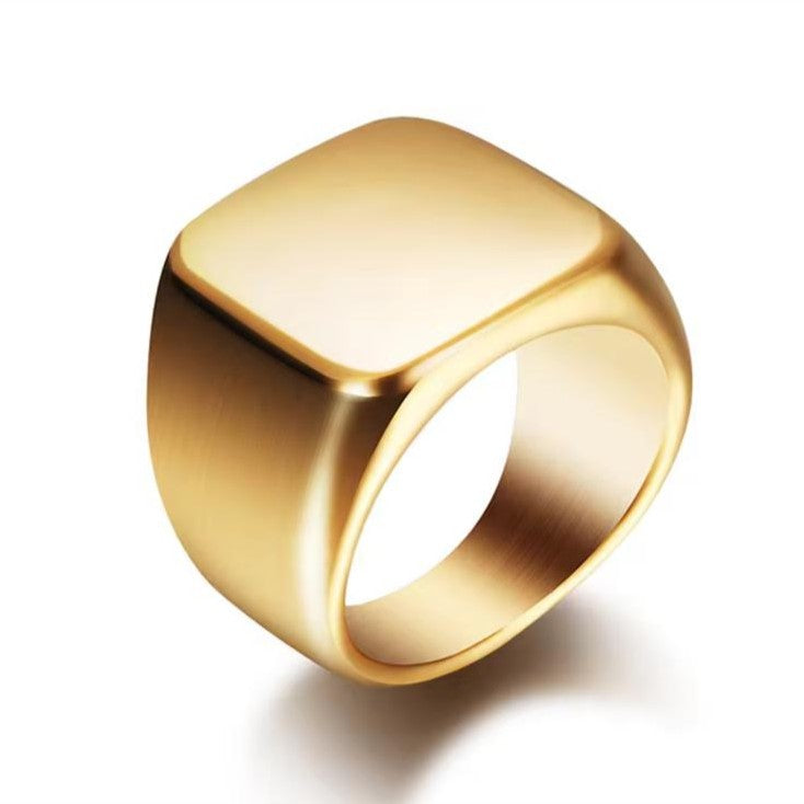 Men's gold engravable signet ring on a white background