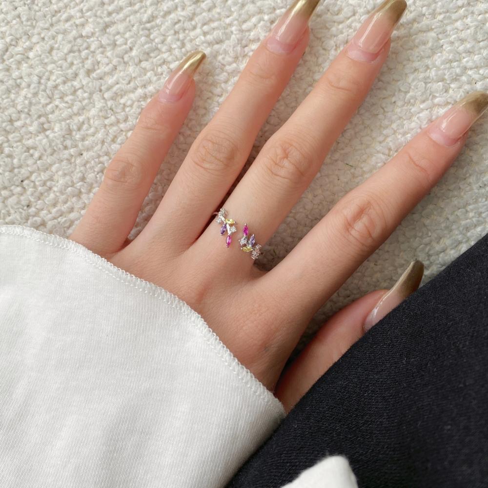An adjustable silver ring featuring a floral design with multiple multicolored gemstones.