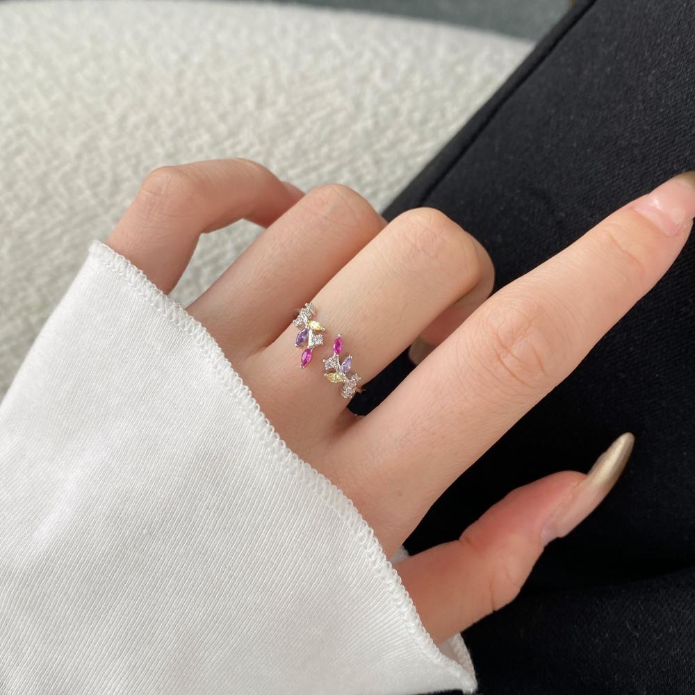An adjustable silver ring featuring a floral design with multiple multicolored gemstones.
