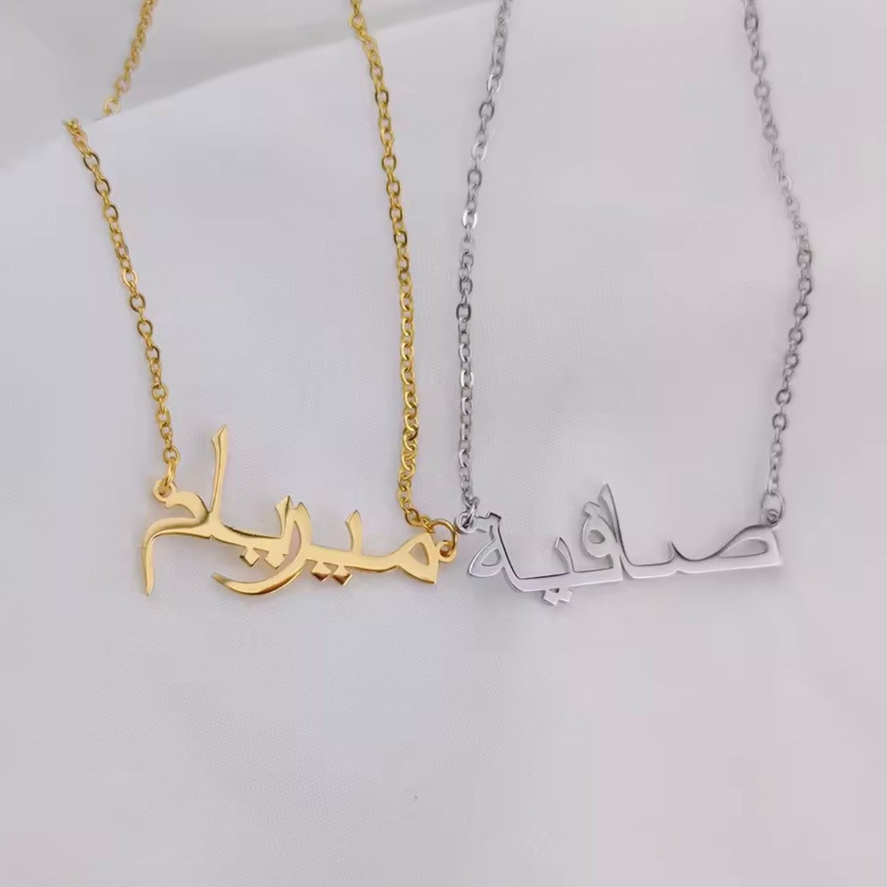 Gold and silver necklaces with Arabic calligraphy on a white background
