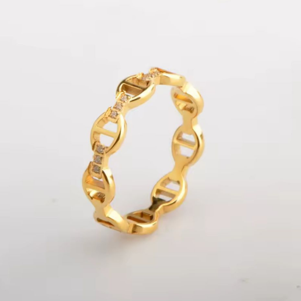 Gold ring with a unique design on a light gray background