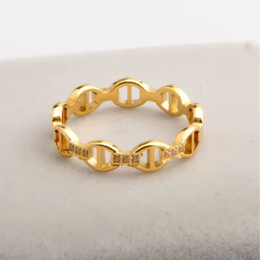 Gold DNA-shaped ring on a light gray background