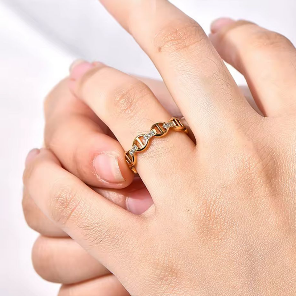 Gold ring on a person's finger against a white background