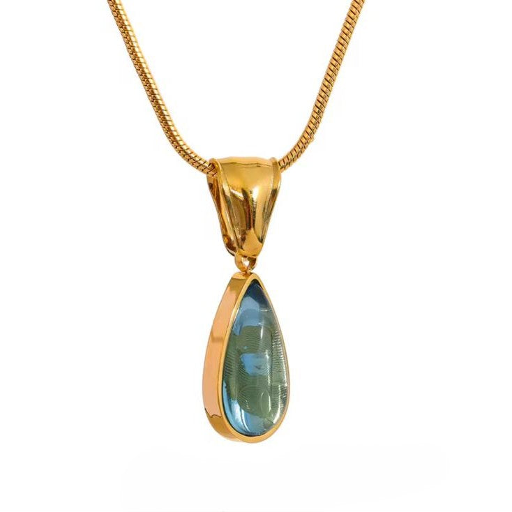 Gold pendant with a green teardrop-shaped gemstone on a white background