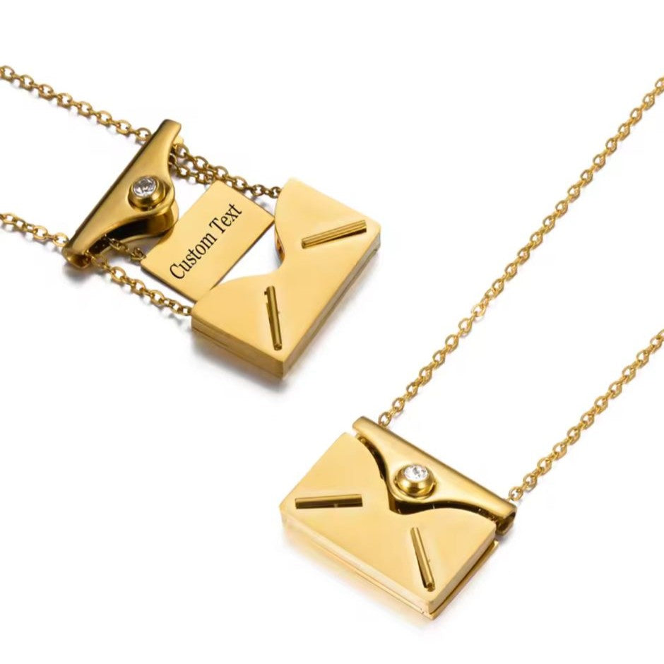 Gold necklace with envelope pendants on a white background