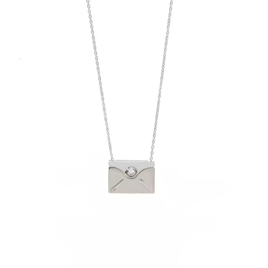 Silver necklace with a diamond-studded pendant on a white background