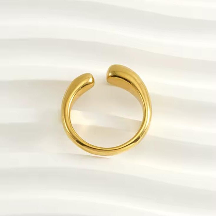 A irregular adjustable gold ring on a white background.