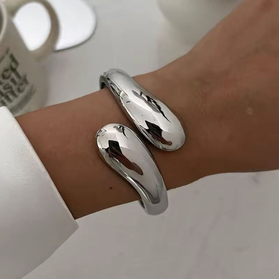 Silver bangle on a wrist with a blurred background