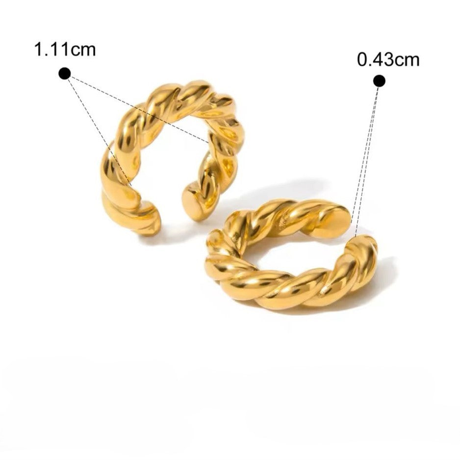 A pair of gold-colored ear cuffs with luxury design displayed on white background.