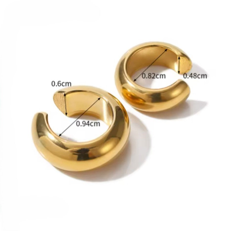 A pair of gold-colored ear cuffs with luxury design displayed on white background.