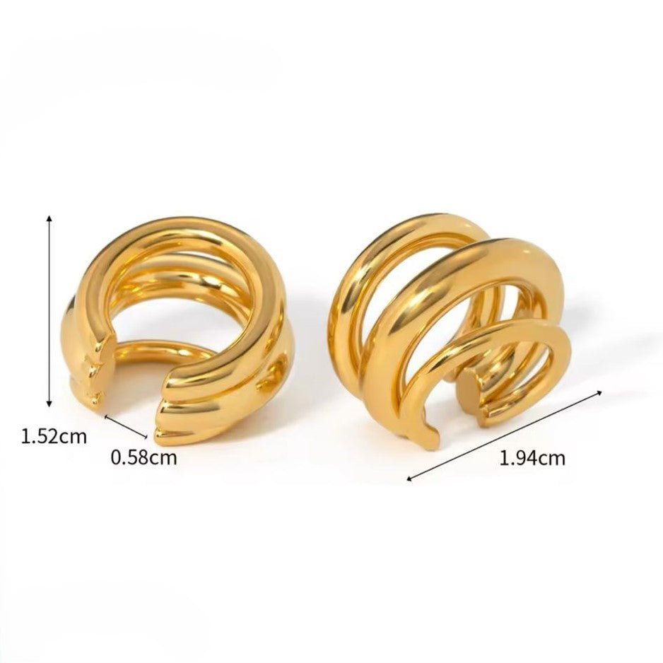 A pair of gold-colored ear cuffs with luxury design displayed on white background.