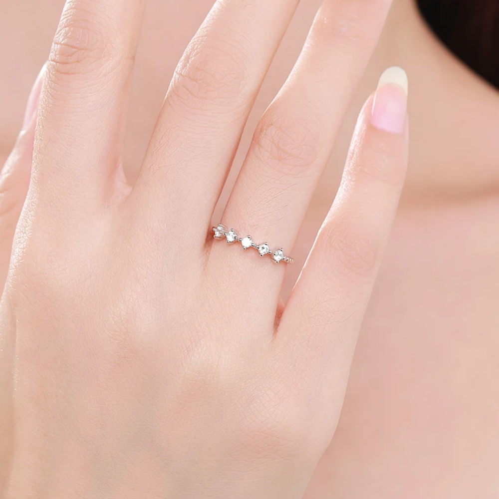 Silver ring with small diamonds on a person's finger