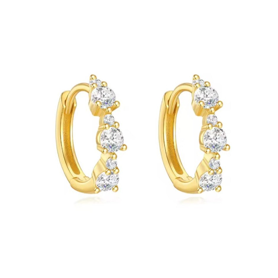 Gold hoop earrings with clear gemstones on a white background