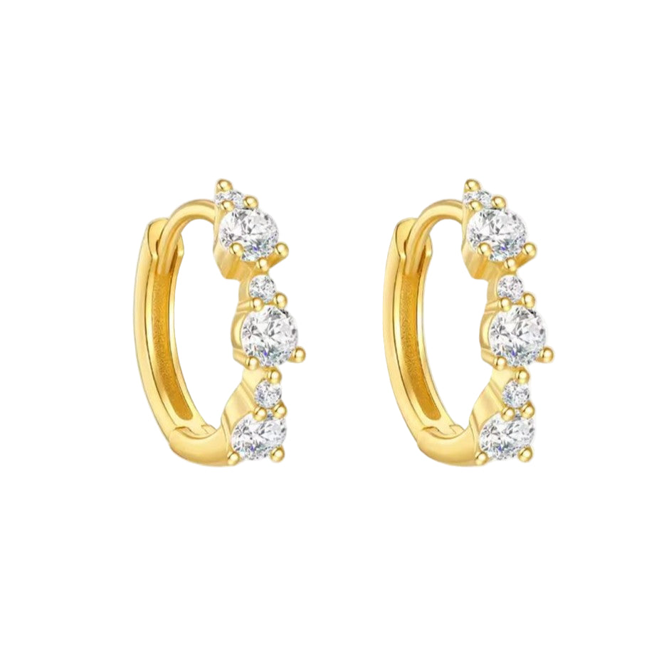 Gold hoop earrings with clear gemstones on a white background