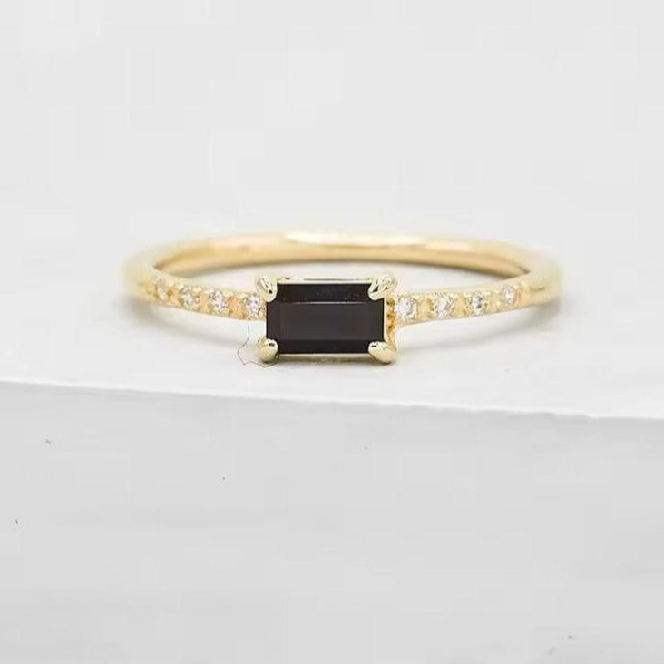 Gold ring with a black gemstone on a white background
