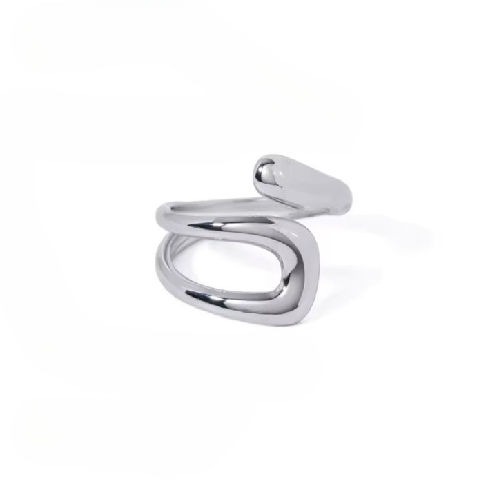 A silver-colored stainless steel hollow layered wide ring is displayed on a white surface in the background.