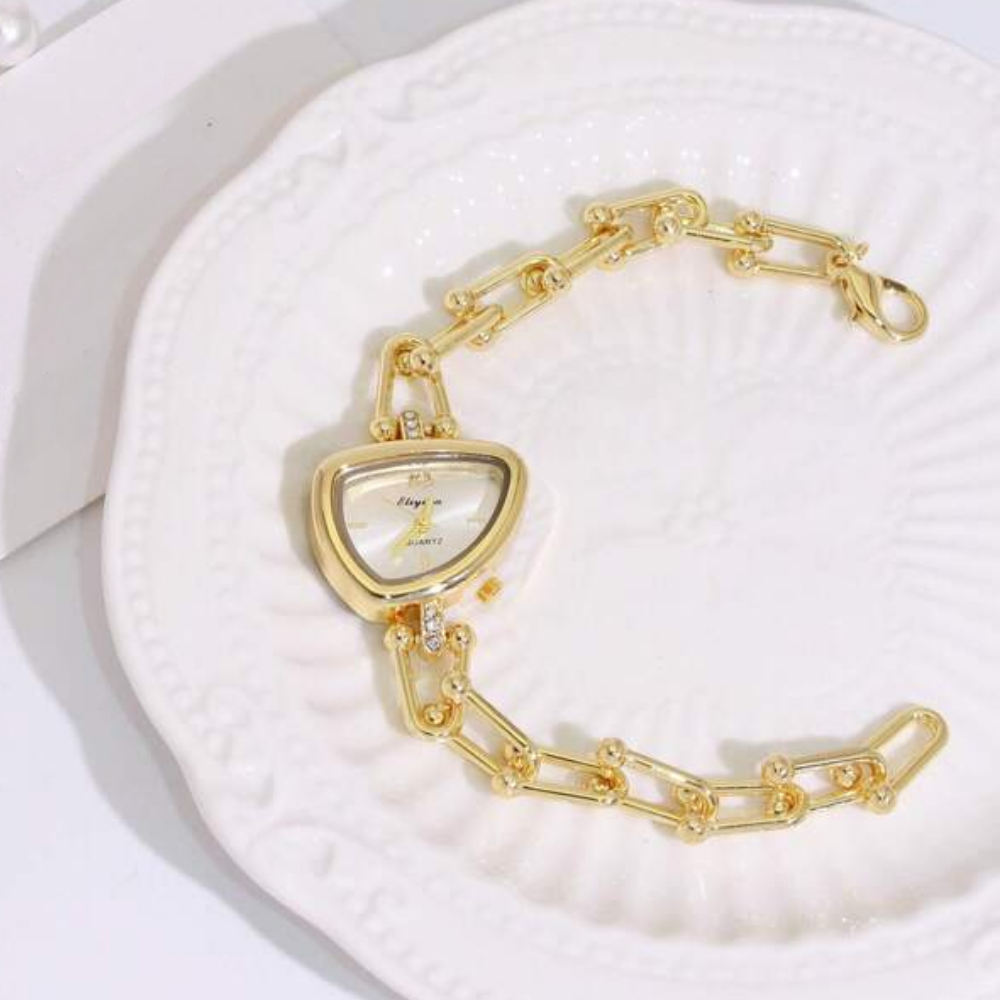 Gold chain-link watch with a oval-shaped face on a white background