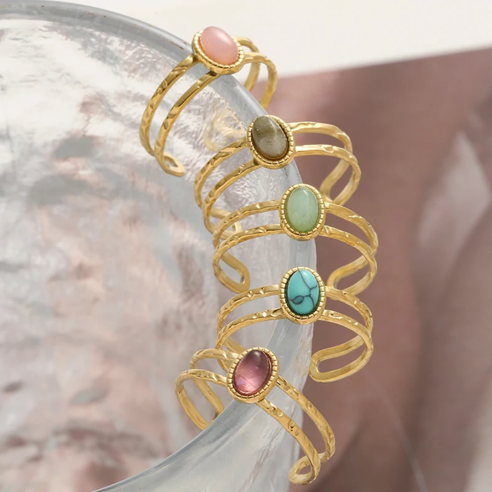 Gold rings with colorful stones on a neutral background
