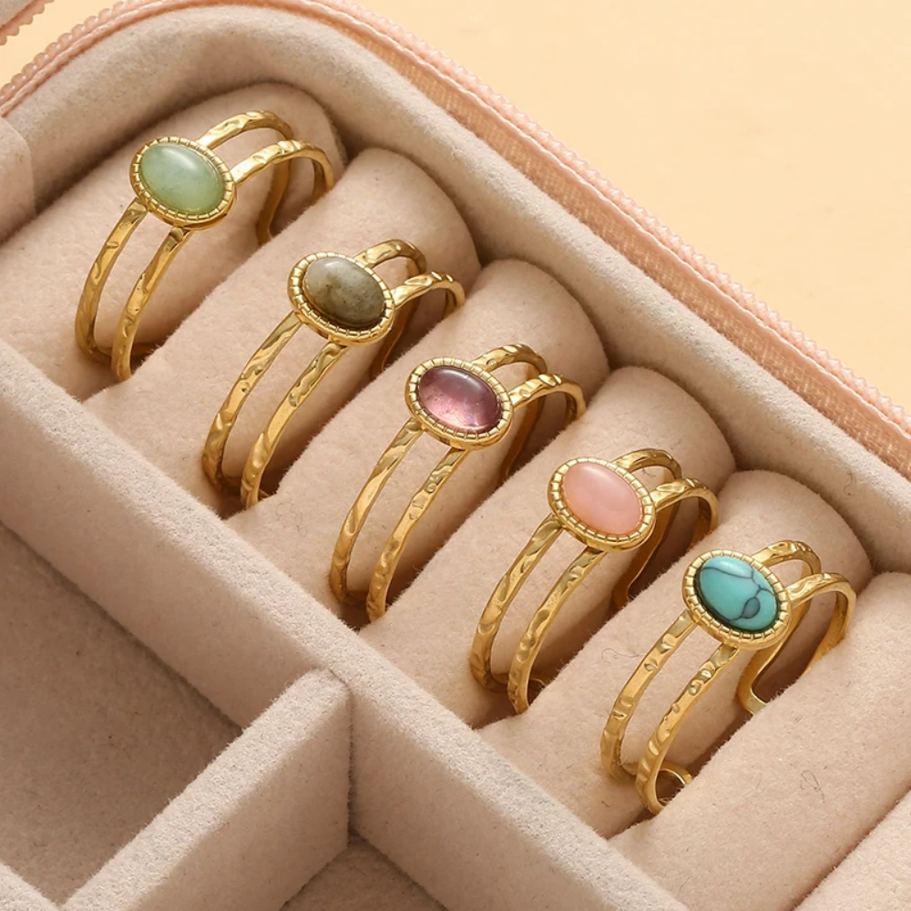 Set of gold rings with colorful gemstones in a jewelry box